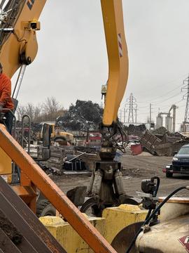 Industrial Excavator Handling Scrap Metal at Recycling Yard