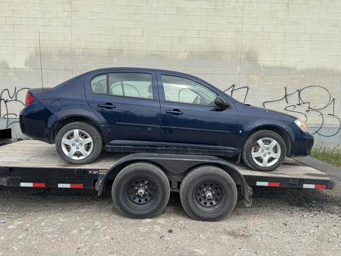 Blue Sedan Loaded on Trailer for Scrap Metal Recycling