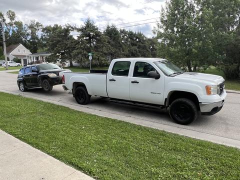 Pickup Truck Towing Scrap Vehicle in Residential Area