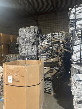 Scrap Metal Recycling Facility with Stacked Materials and Cardboard Box